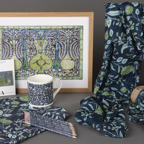 Displayed together is a framed print, fridge magnet, mug, pencils with an eraser top, cotton tea towel and a draped scarf. Decorated with blue, green and white botanical illustrations, they are from an exclusive Vases and Cypress Trees collection.