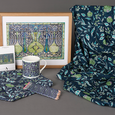 Displayed together is a framed print, fridge magnet, mug, pencils with an eraser top, cotton tea towel and a draped scarf. Decorated with blue, green and white botanical illustrations, they are from an exclusive Vases and Cypress Trees collection.