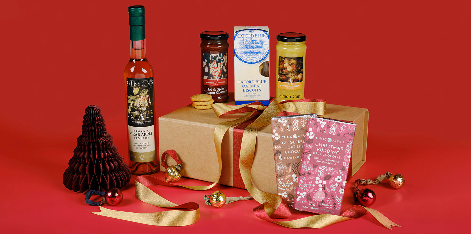 Gibson's Liqueur Hamper, which also includes two preserves, two festive chocolate bars and a pack of Oxford Blue oatmeal biscuits. Decorated with gold ribbon.