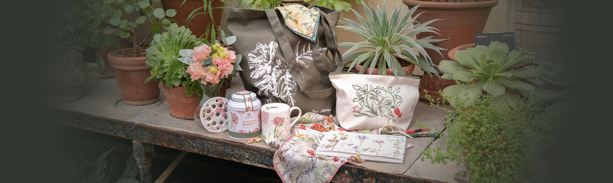 Collection of May Morris bespoke products surrounded by terracotta potted plants