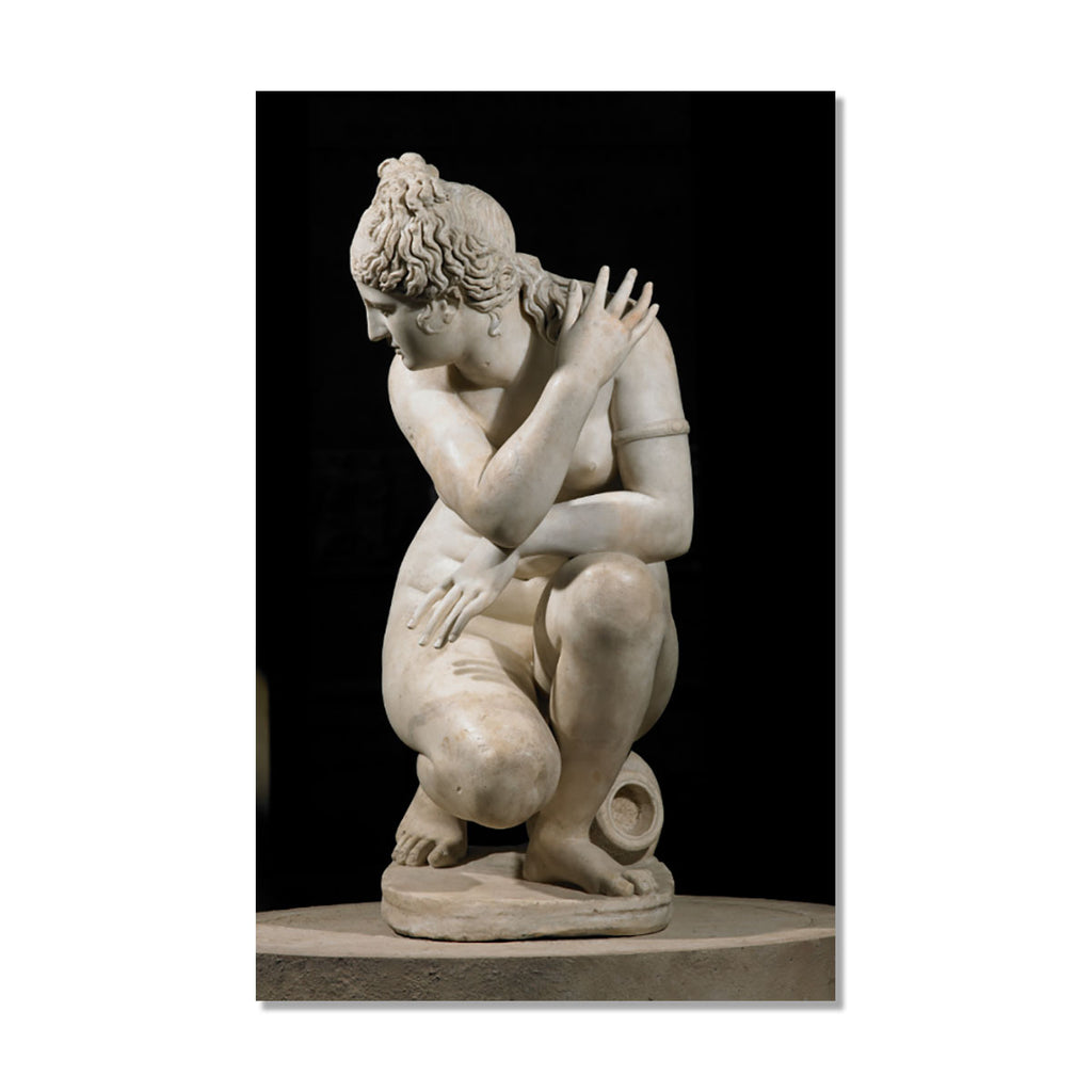 A classical marble sculpture of a crouching nude female figure, shown against a black background with a thin white border around the print.