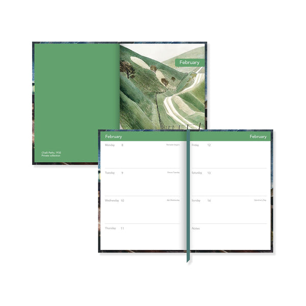 Green planner with a scenic cover and open to a calendar page.