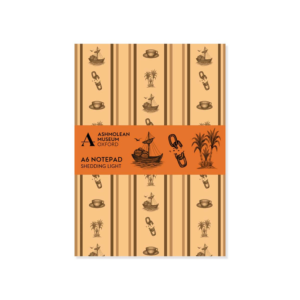 A6 paper notepad with a brown wallpaper pattern of broken chains, sugar cane, teacups and ships with Ashmolean branded orange bellyband on a white background.