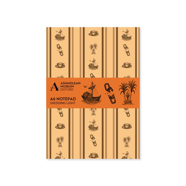 A6 paper notepad with a brown wallpaper pattern of broken chains, sugar cane, teacups and ships with Ashmolean branded orange bellyband on a white background.