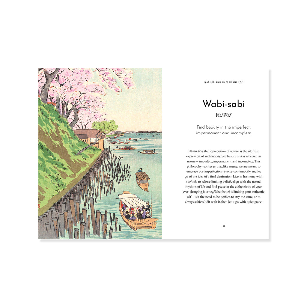 An open book or booklet spread showing a watercolor-style illustration on the left with cherry blossoms, a shoreline, boats, and water, alongside a printed text page on the right titled 'Wabi-sabi' with a Japanese character and explanatory text.