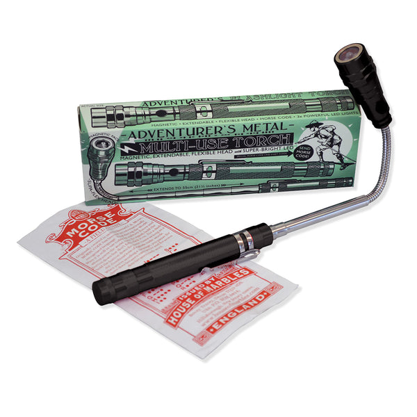 Extendable metal hand torch with LED head and copy of morse code sheet on a white background.