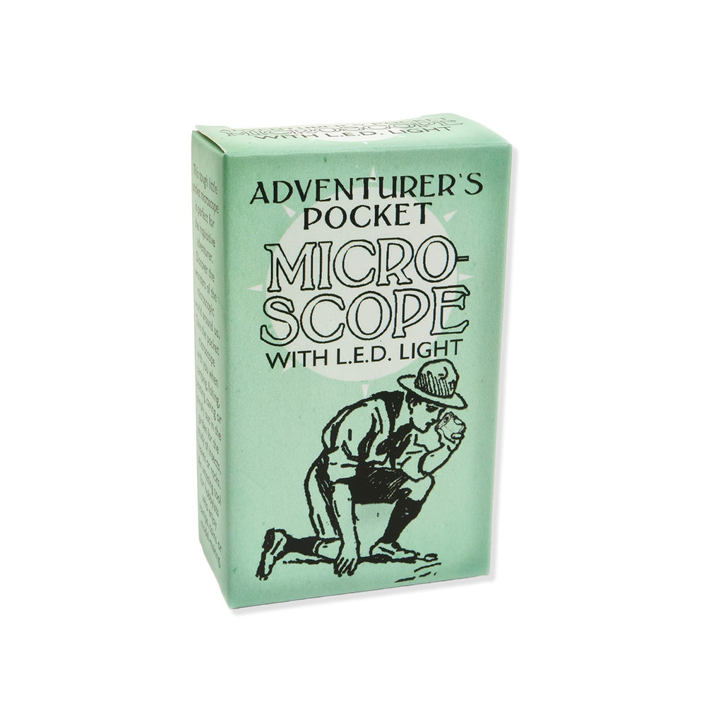Green box with 'ADVENTURER'S POCKET MICRO-SCOPE WITH L.E.D. LIGHT' text and a black graphic of boy scout styled model with hat using microscope to look on ground on a white background.