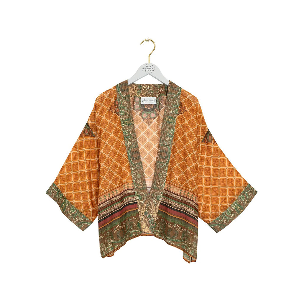 An orange patterned open-front kimono with wide sleeves, hanging on a white hanger against a plain white background.