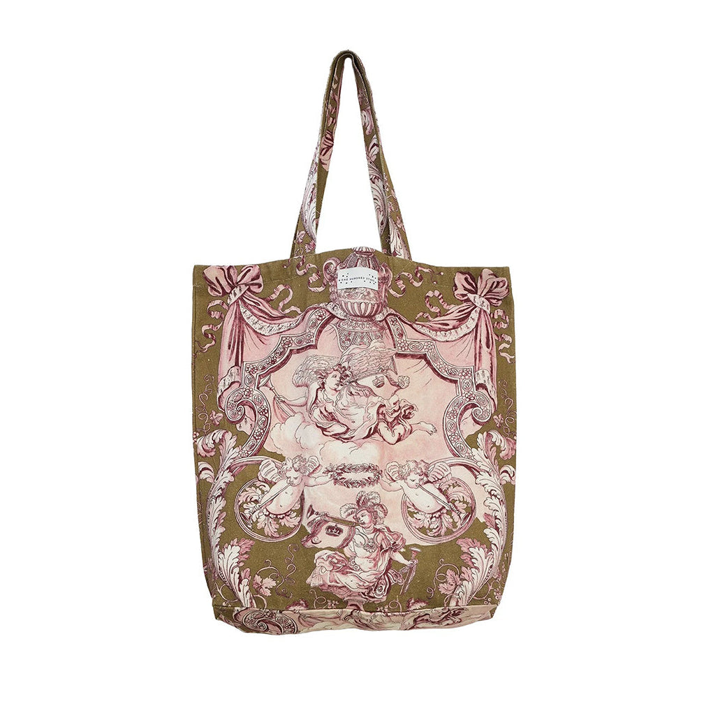 A canvas tote bag featuring a vintage-style toile de Jouy print with pink cherubs and scrollwork on an olive green background, set against a plain white studio background.