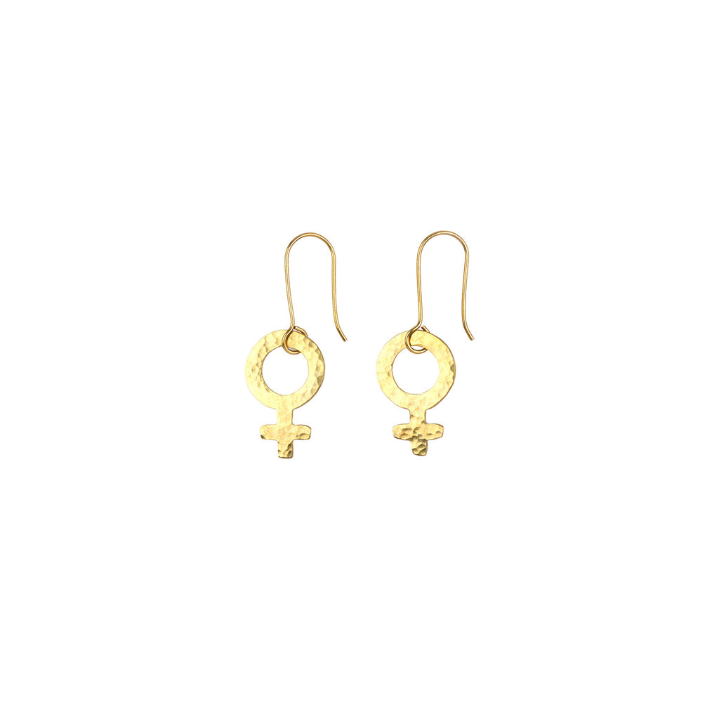 A pair of gold dangle earrings featuring a hammered circular ring with a Venus symbol charm, suspended from fishhook wires on a plain white background.