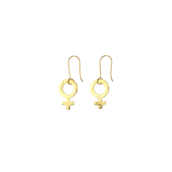 A pair of gold dangle earrings featuring a hammered circular ring with a Venus symbol charm, suspended from fishhook wires on a plain white background.
