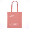 A dusty pink canvas tote bag with white printed text reading 'ASHMOLEAN MUSEUM OXFORD' and 'APHRODITE THE MAKING OF A GODDESS'.