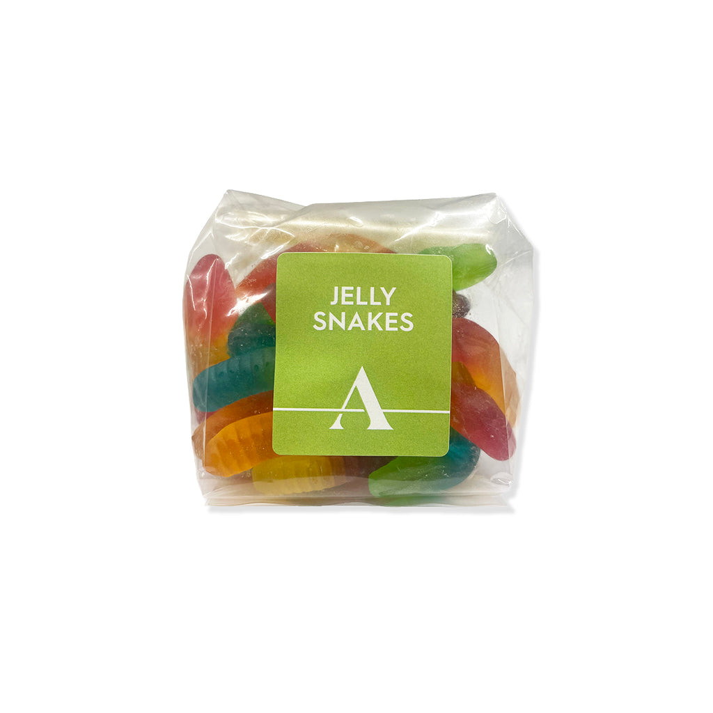 A clear plastic bag of colorful jelly snakes gummy candies with a green label that reads 'JELLY SNAKES' and features a white stylized 'A' logo, set against a plain white background.