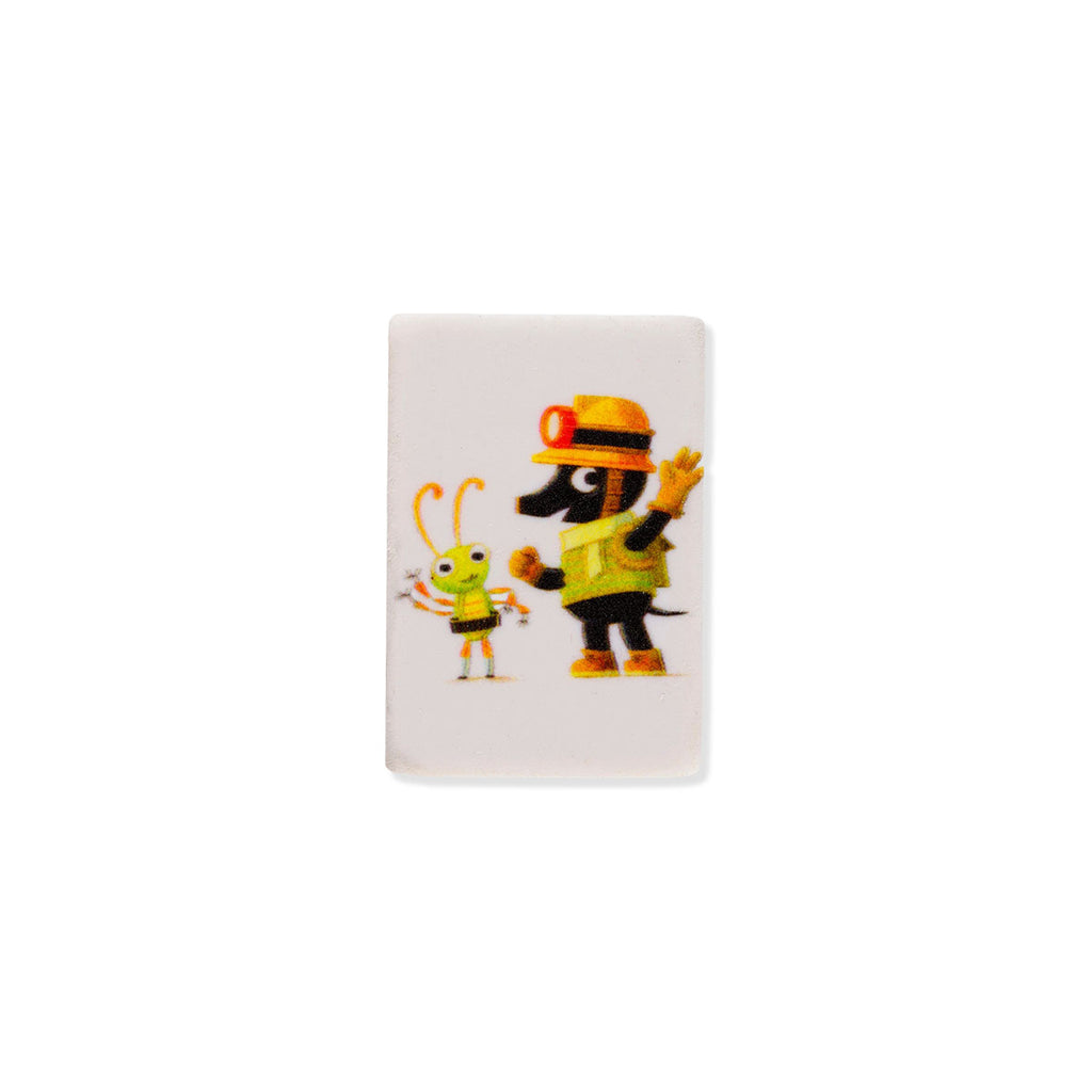 A white rectangular rubber eraser featuring a colourful cartoon illustration of a black mole dressed as an adventurer explorer, wearing a yellow hard hat and vest next to a small green and yellow beetle character, set against a plain white background.