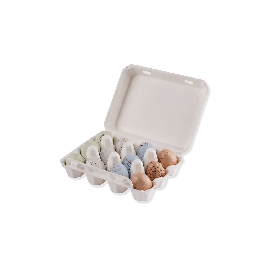 Open egg carton box with speckled green, white, blue and brown chocolate eggs on a white background.