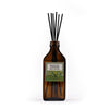 Brown diffuser bottle with black reeds and a label on a white background