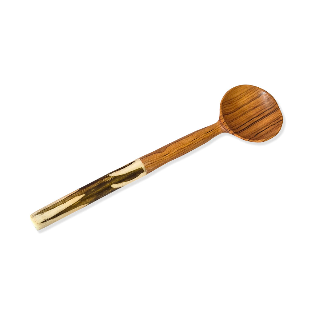 Olive wood grain spoon with black batik style inlaid handle on a white background.