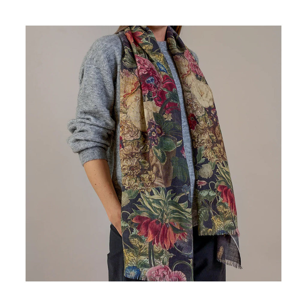 Model wearing a colourful floral black wool scarf with a neutral background