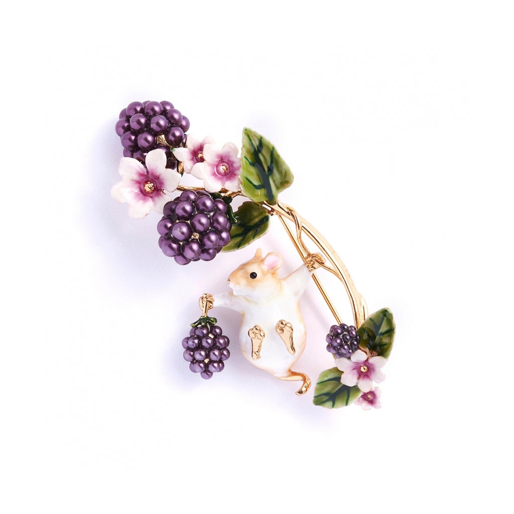 A gold-plated, hand-enamelled brooch featuring a field mouse swinging from a blackberry branch with deep purple faux pearls on the blackberries.