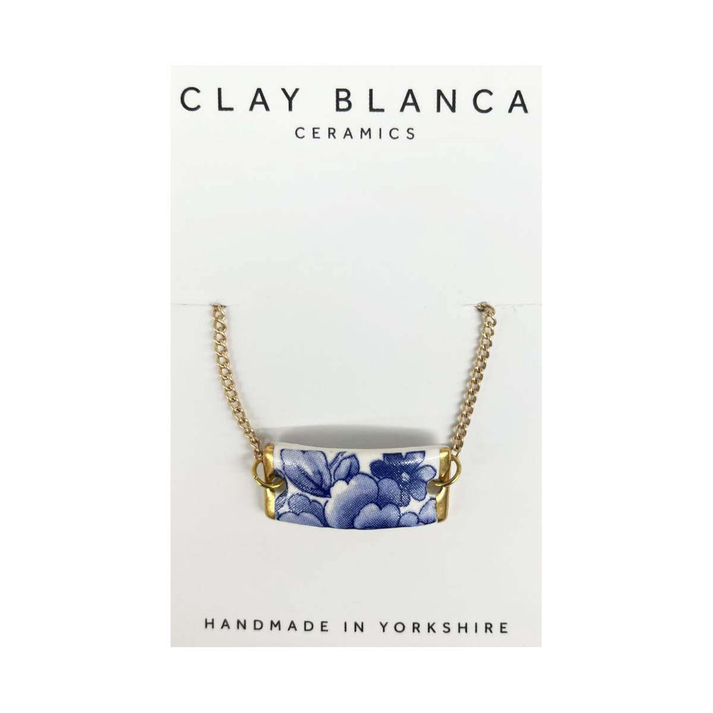 Porcelain ID style bracelet with blue and white delft pottery style floral design and gold metal chain on white background