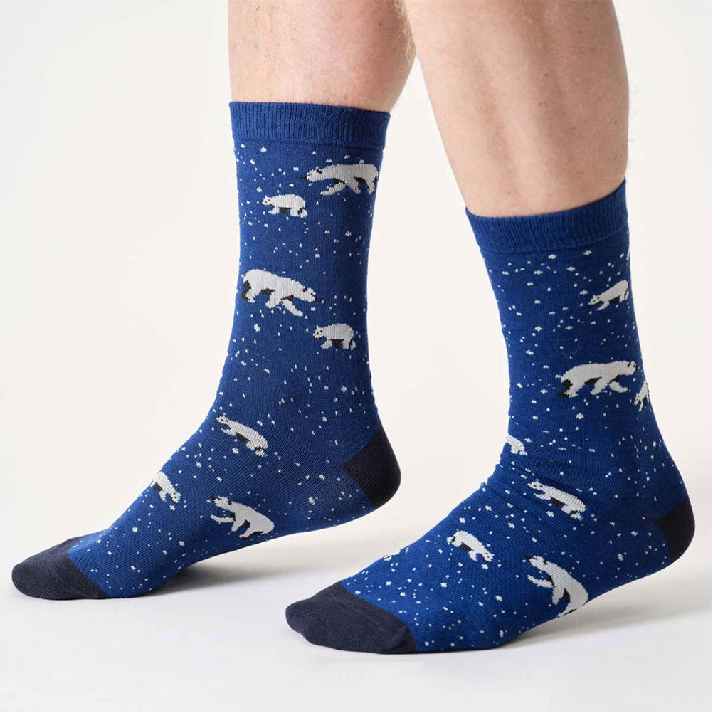 Blue socks with polar bear pattern worn by a person on a white background