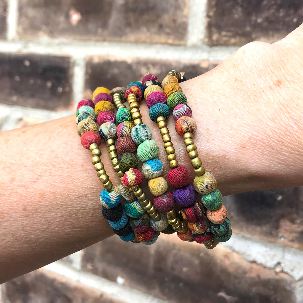 Multicolored beaded bracelets on a wrist with a blurred background