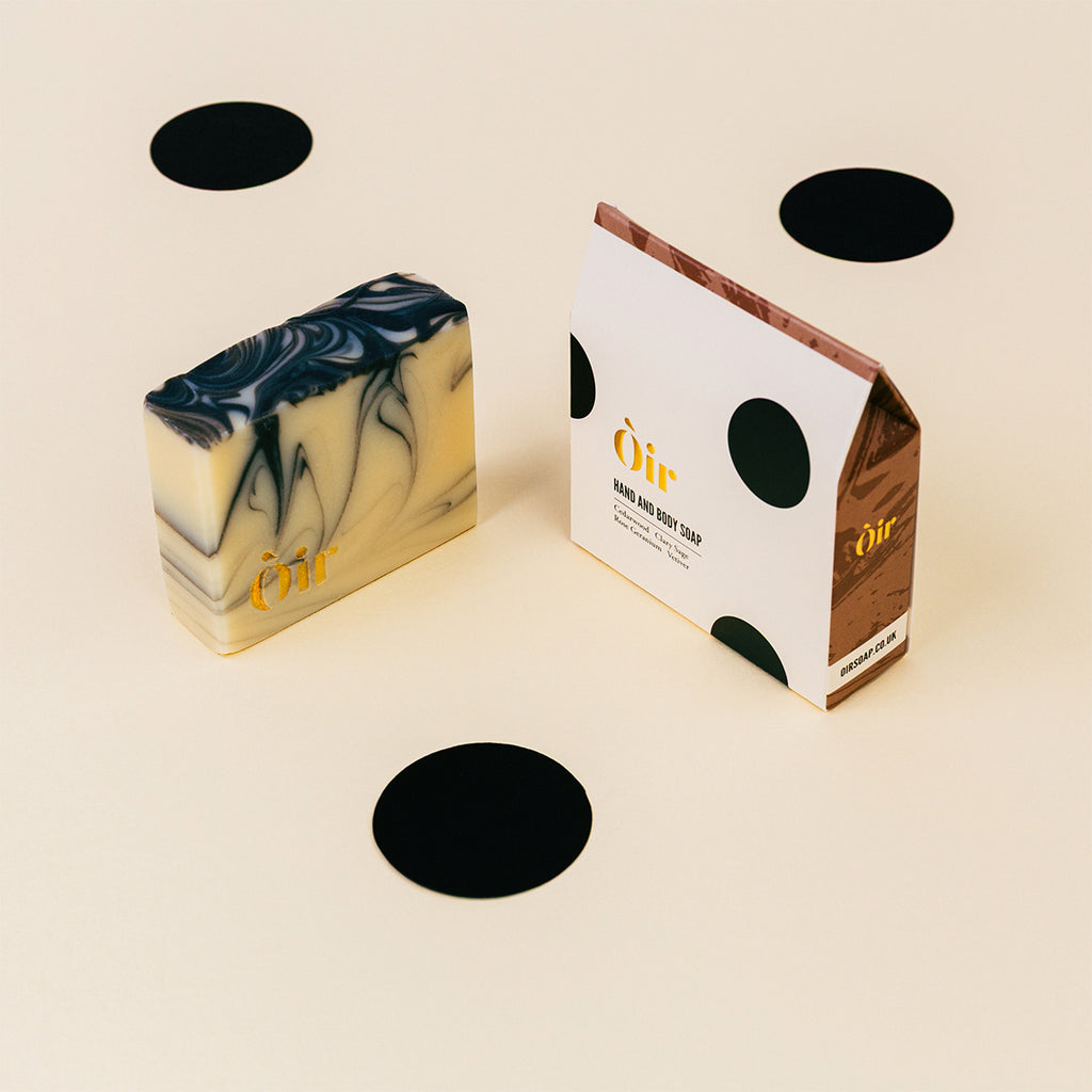 Marbled soap bar with packaging on a beige background