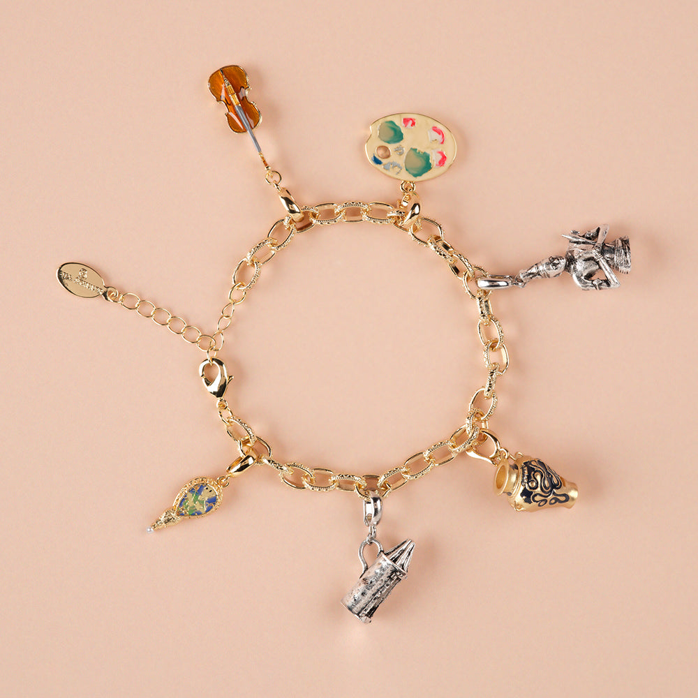 Gold bracelet with various charms on a beige background