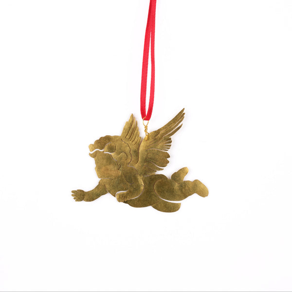 A small winged cherub ornament in a metallic gold finish, suspended by a red hanging ribbon against a plain white background.