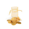 Gold chocolate coins spilling out of a gold drawstring bag on a white background