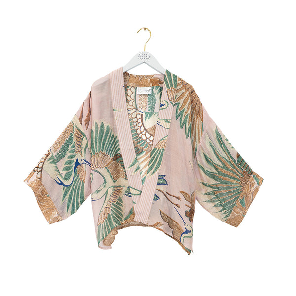 Pink kimono-style jacket with green and brown leaf patterns on a white background