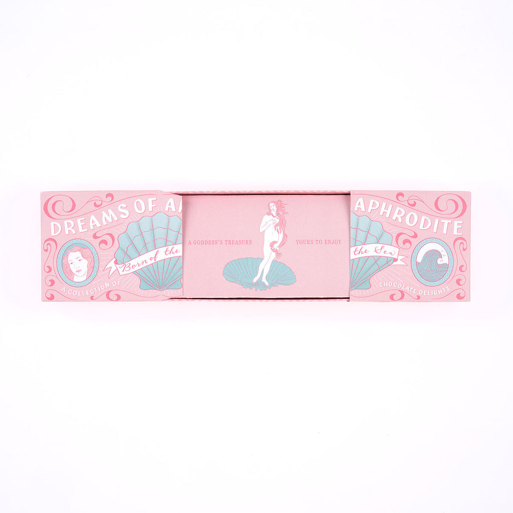 A pink rectangular chocolate box with decorative vintage-style artwork and the text 'DREAMS OF APHRODITE'.
