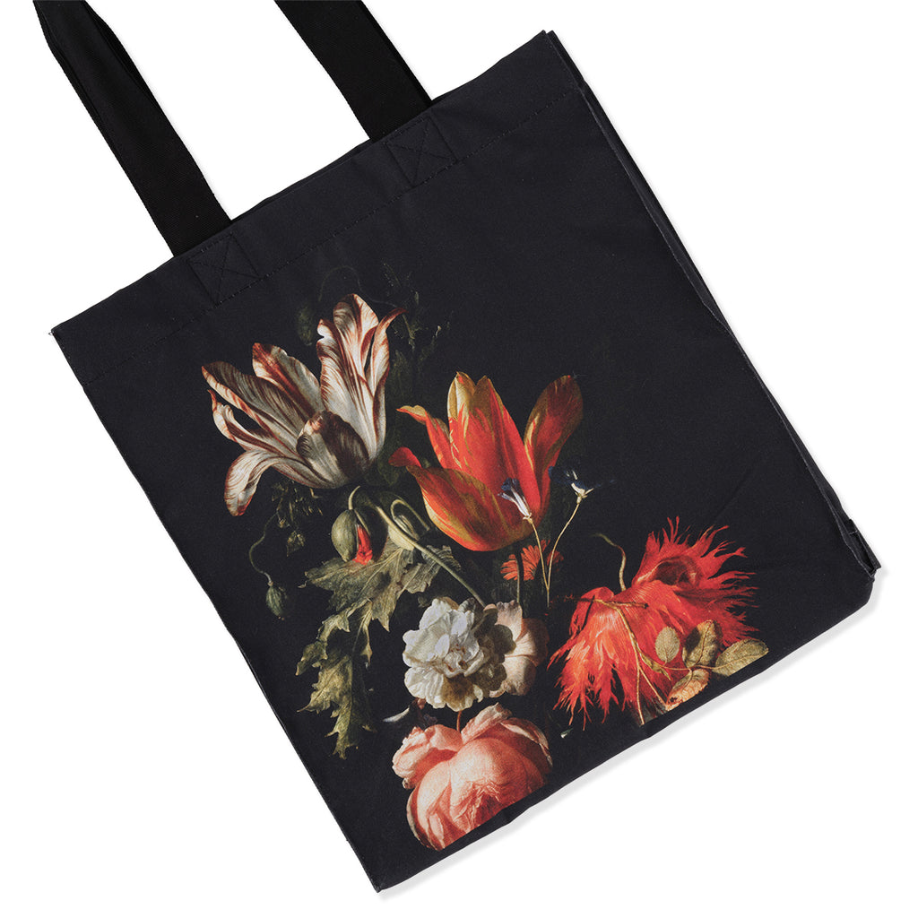Close up detail of Verelst Flowers artwork on black cotton canvas tote bag with Dutch still life flowers painting print on a white background.