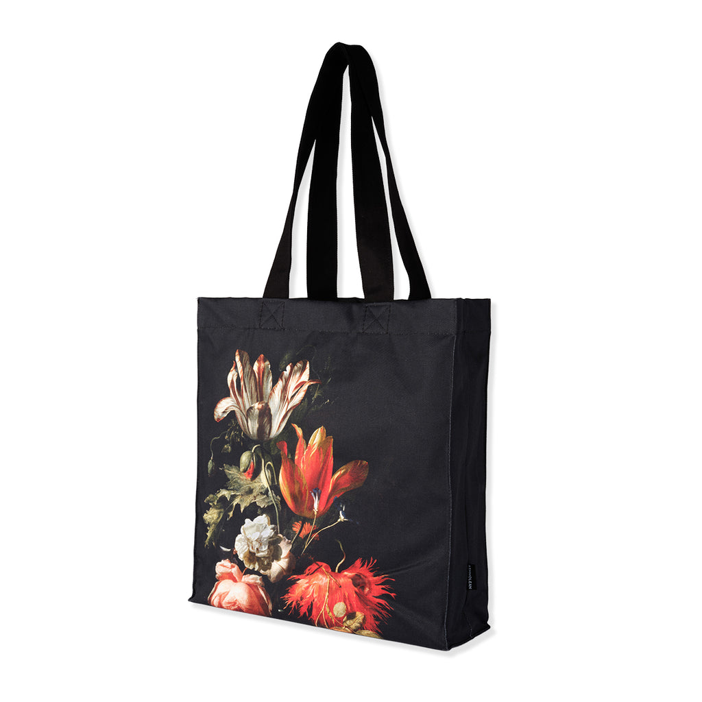 Gusseted black cotton canvas tote bag with Dutch still life flowers painting print on a white background.