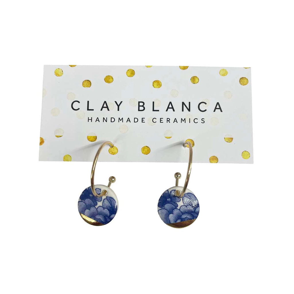 Gold hoop earrings with blue floral designs against a white background