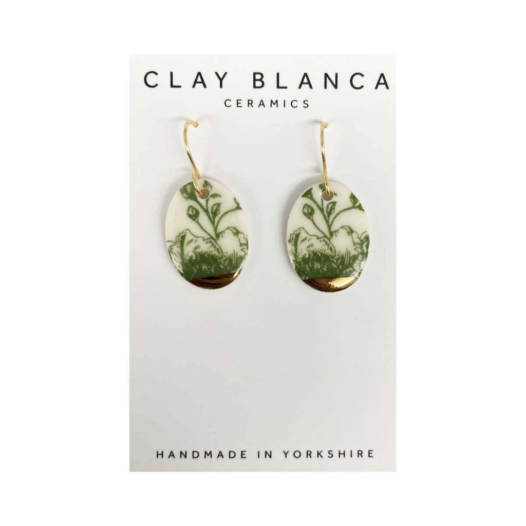 Green leaf design porcelain oval drop earrings on a white card with Clay Blanca branding.