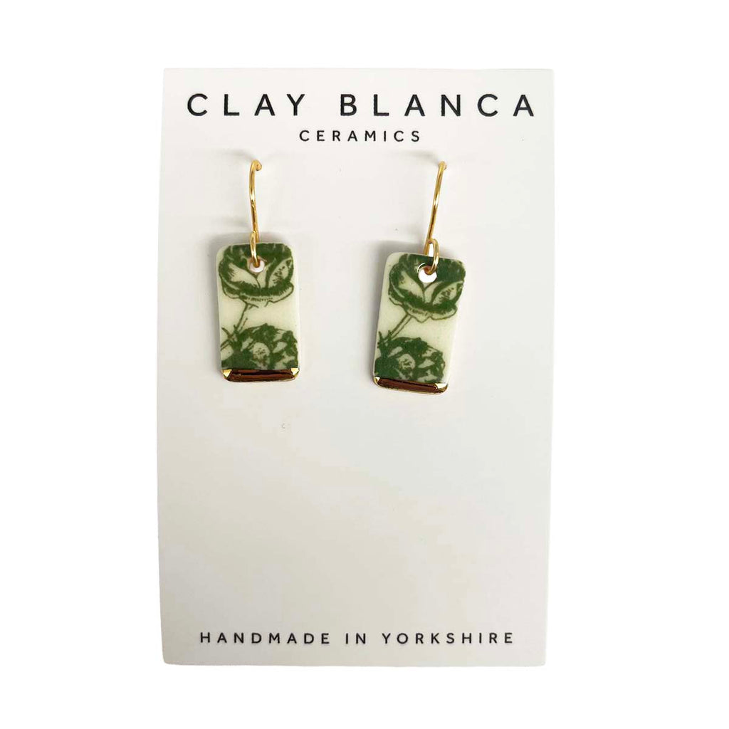 Pair of green floral ceramic earrings on a Clay Blanca card.