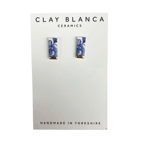 Pair of earrings on a Clay Blanca Ceramics card with floral design