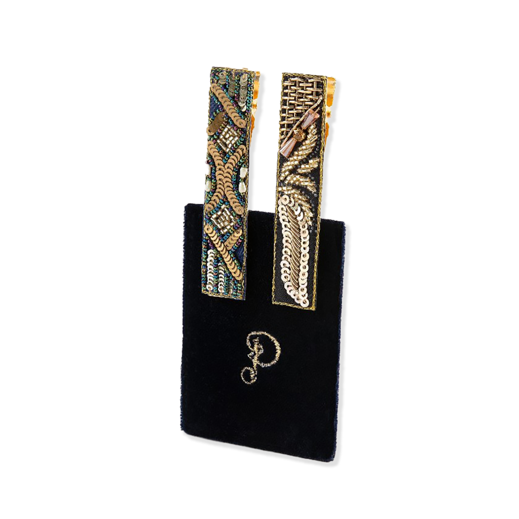 Pair of decorative earrings with intricate patterns on a black velvet backing card.