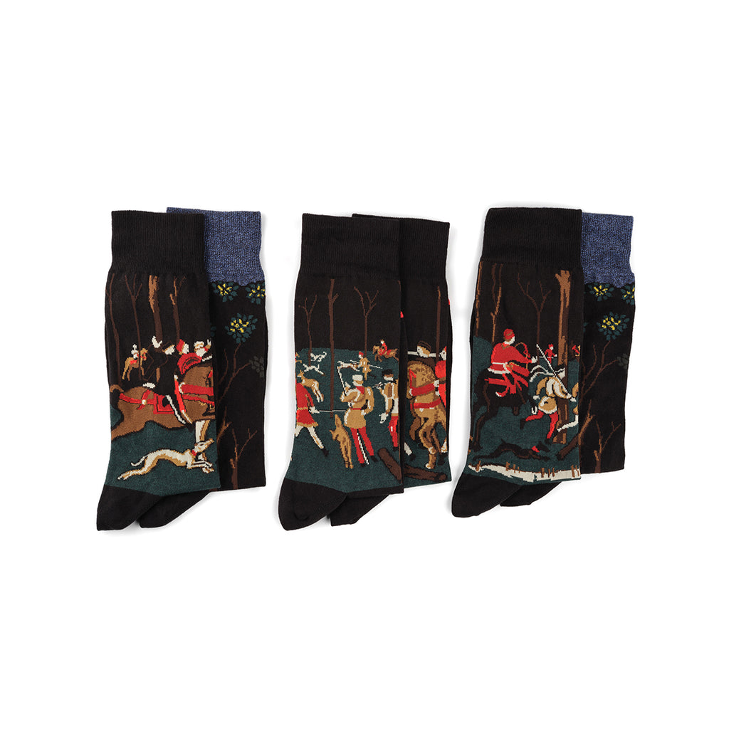 A set of three socks with a printed design depicting a hunting scene in a forest, presented against a white background.