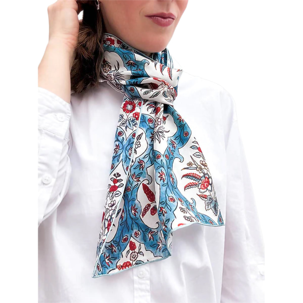 Woman wearing a floral patterned scarf on a white background