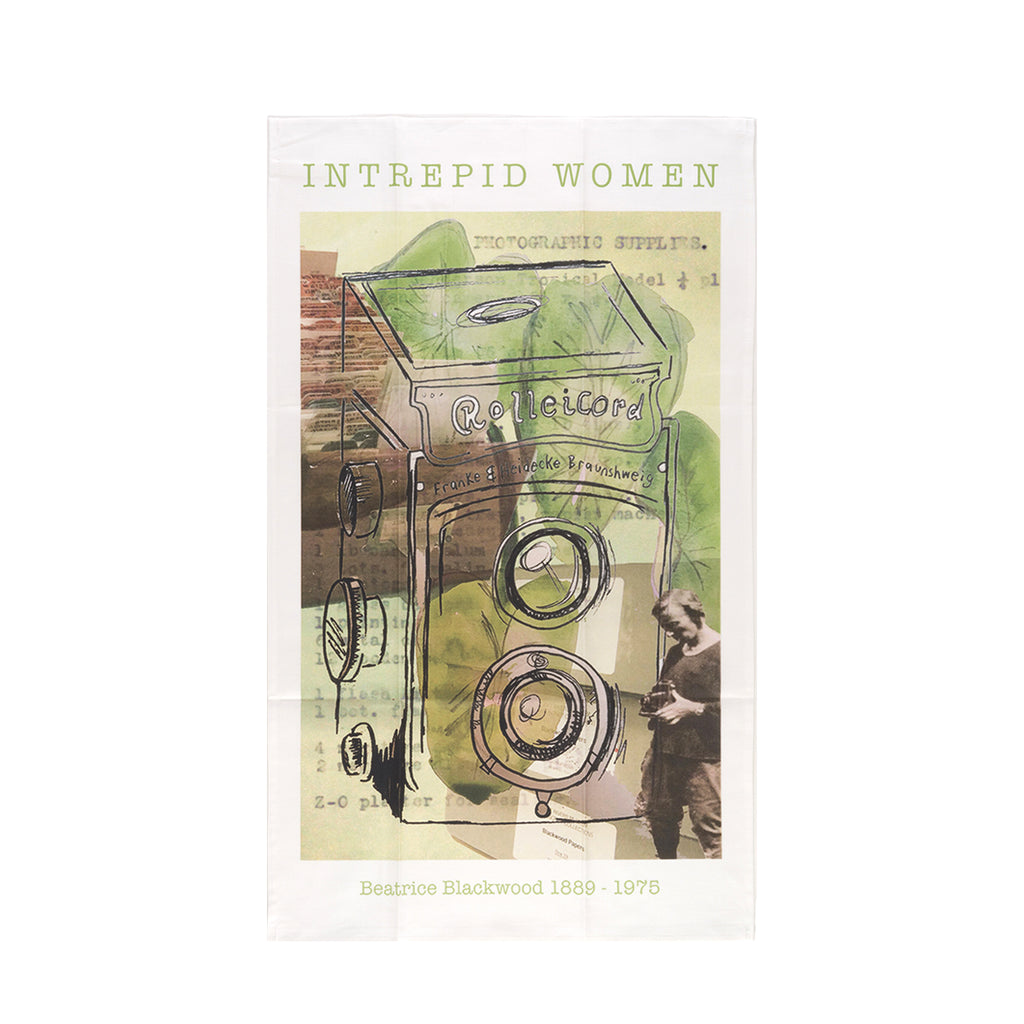 Beatrice Blackwood tea towel with a full image of Beatrice in the buttom right corner holding a camera. Large see through camera covers most of the tea towel with leaves in the background