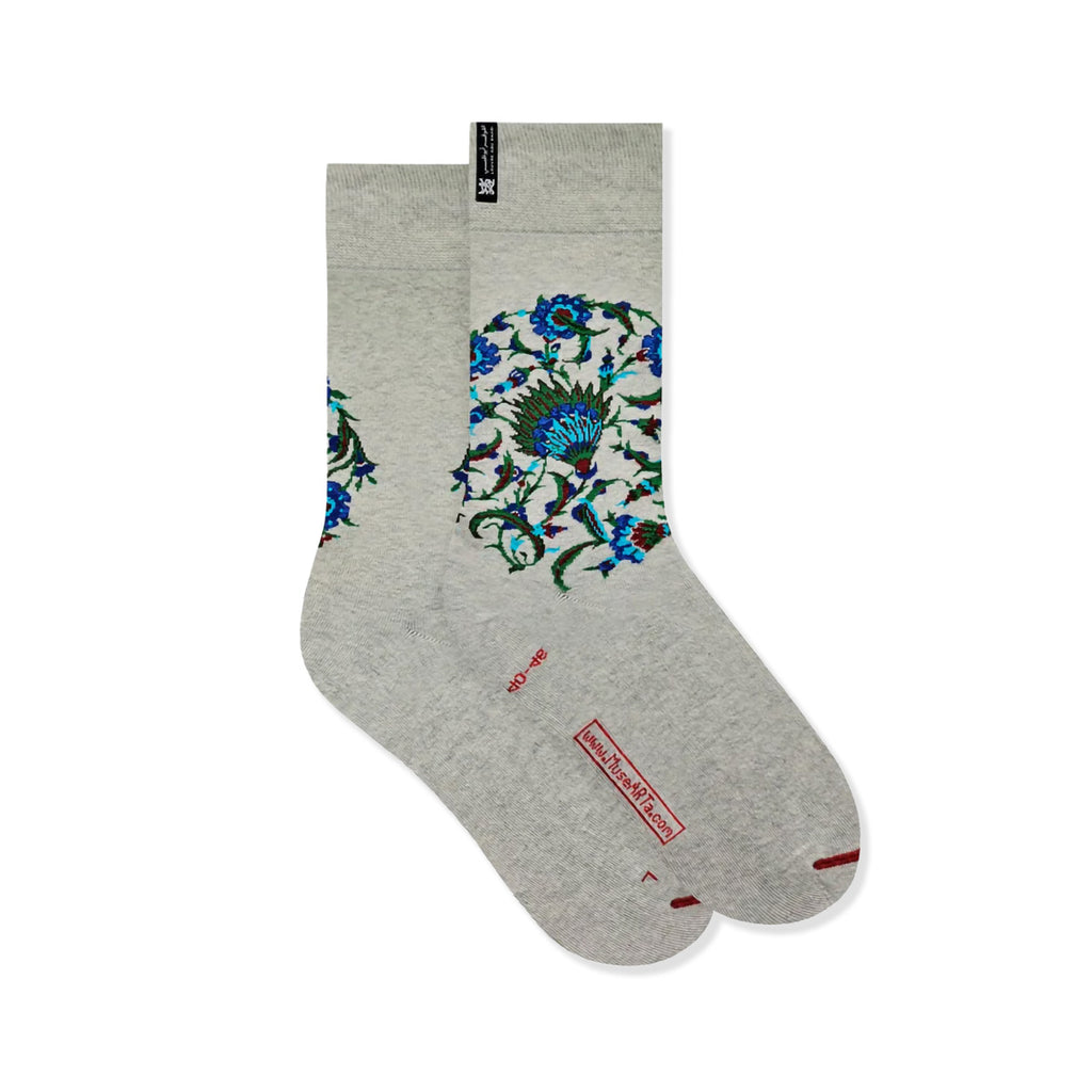 Pair of cream and grey coloured cotton socks with floral pattern in the Iznik pottery style on a white background.