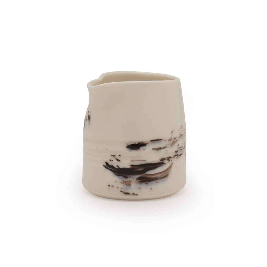 White porcelain jug with black brushstroke design against a white background
