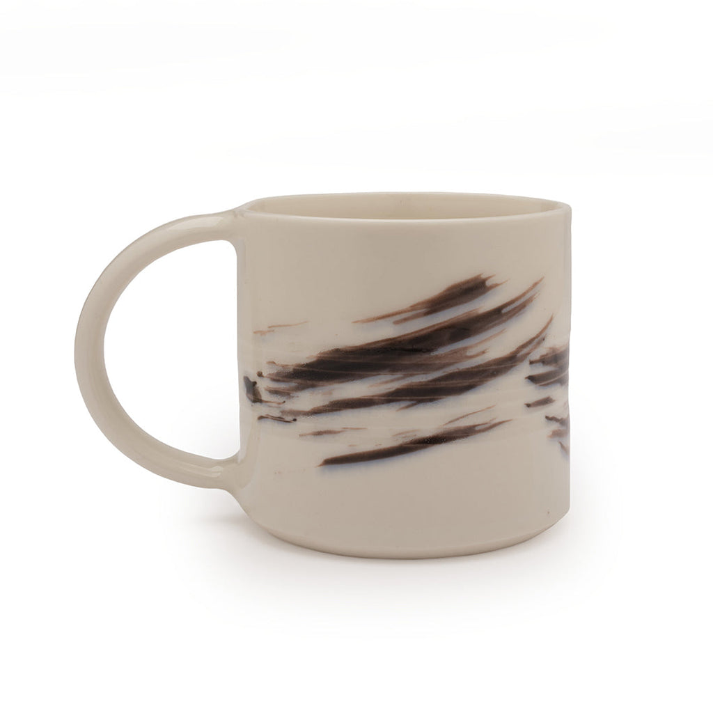 White mug with black brushstroke design against a white background