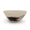 White porcelain bowl with black brushstroke design against a white background