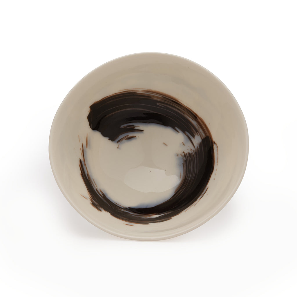 Upright white porcelain bowl with black brushstroke design against a white background