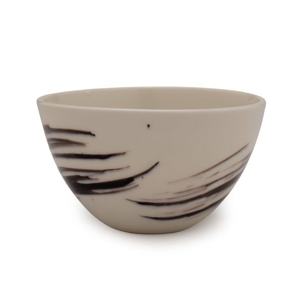 White porcelain bowl with black brushstroke patterns against a white background