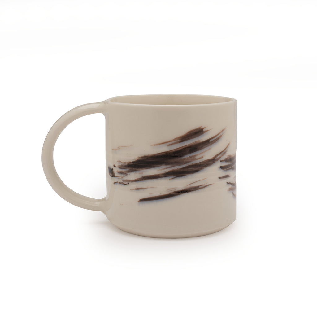 White mug with black brushstroke design against a white background