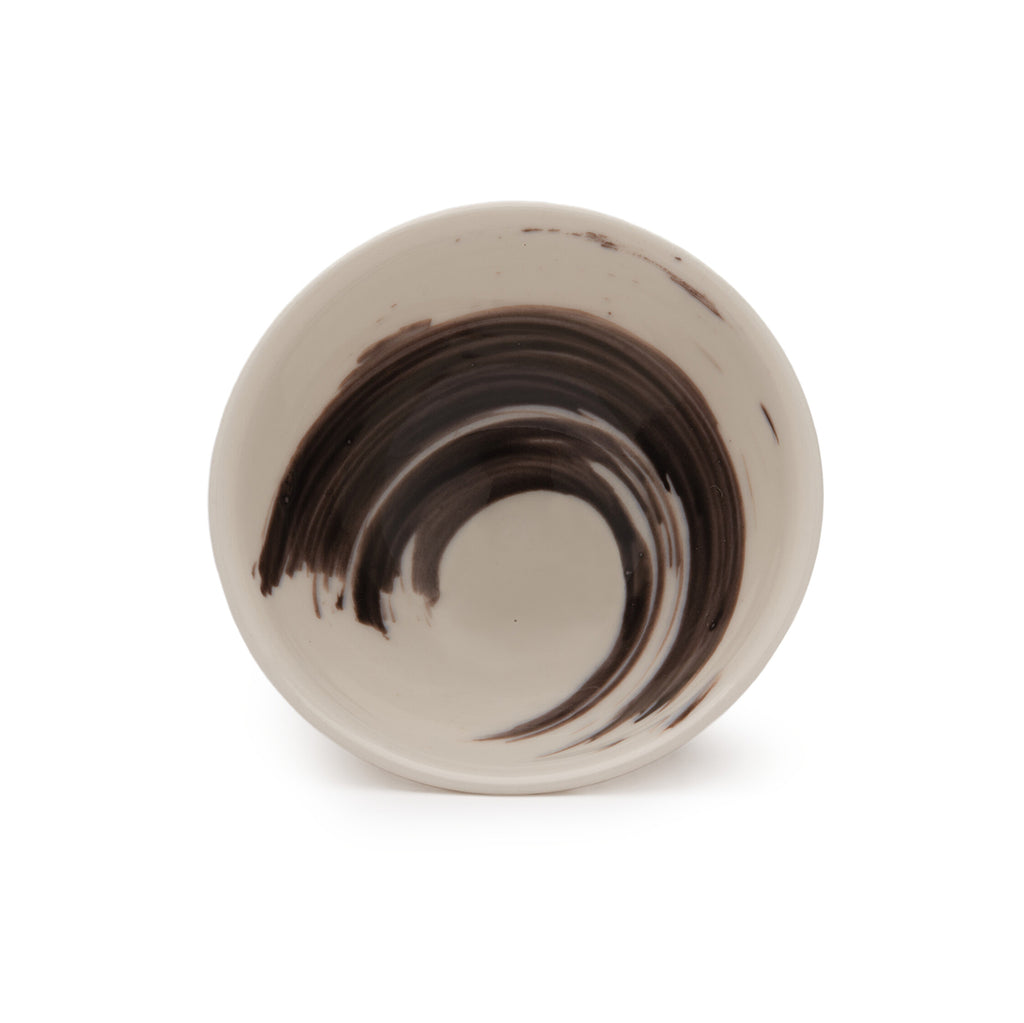 Upright circular white dish with black brushstroke detailing.
